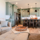 Kitchen viewed from the living room of home with upholstered table and armchairs